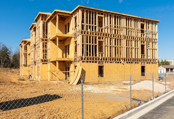 workers protected by temporary barrier fence during building maintenance in West Warwick